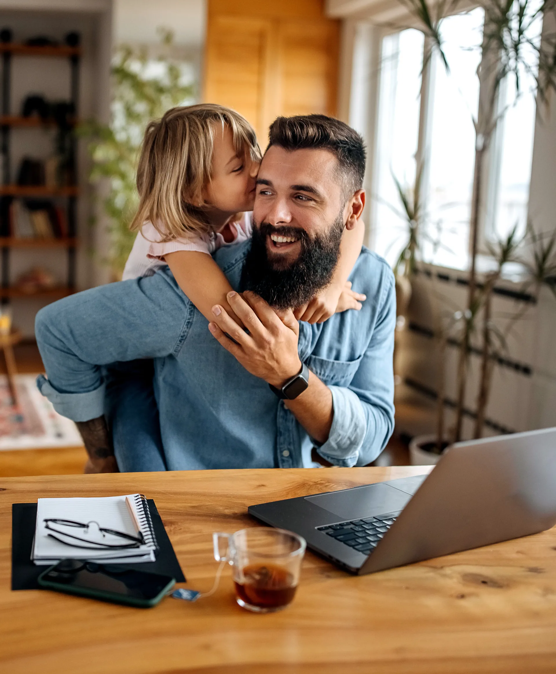 Woman working on laptop with baby sitting on the floor nearby