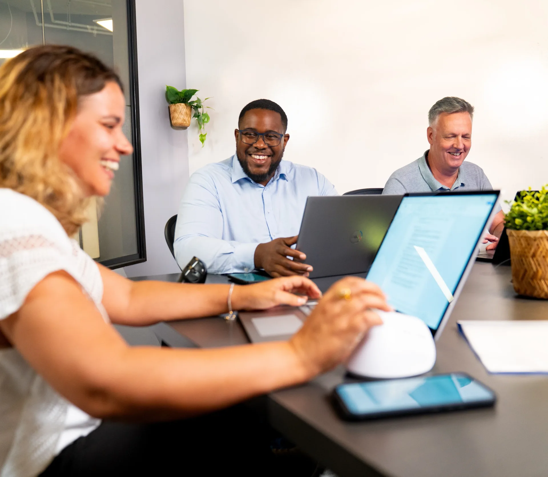 Colleagues in an office collaborating with laptop and Omna AI device
