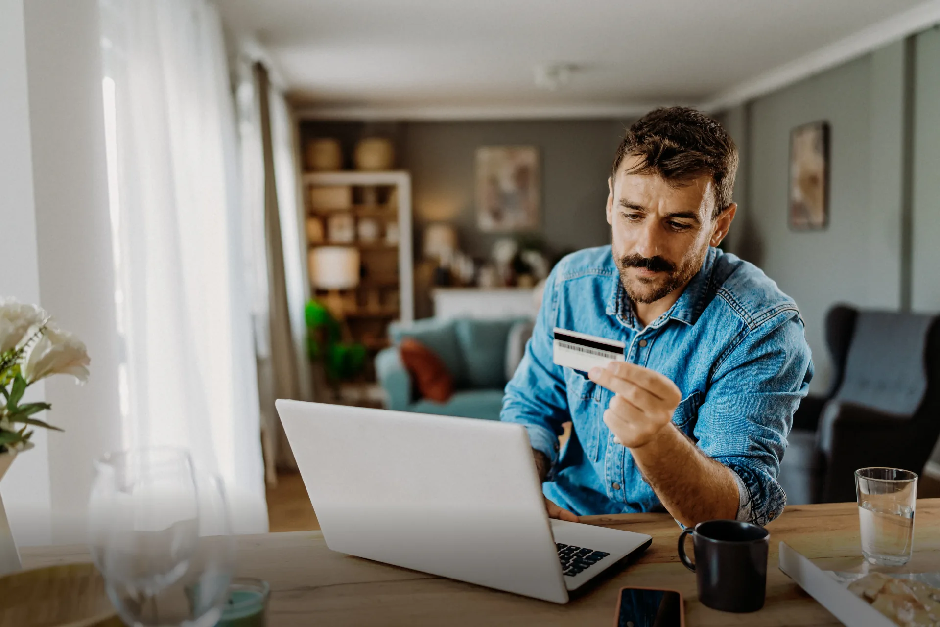 Man holding payment card at laptop table representing predictable token-free AI costs