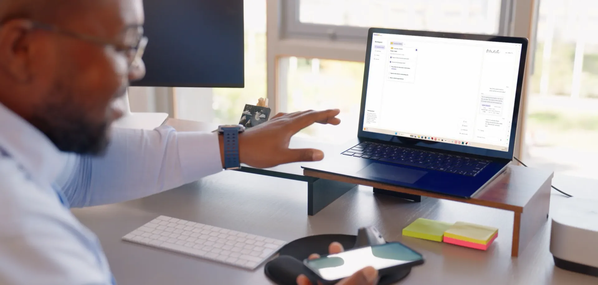 Professional seamlessly shifting between smartphone and laptop workspace